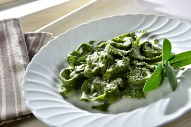 Tabakta adaçayı servis edilen yeşil ıspanaklı tortelloni.