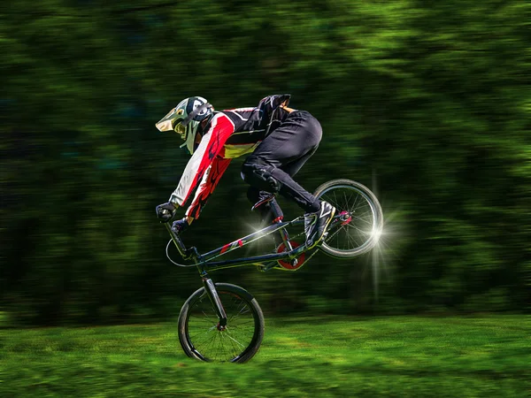 หนุ่ม bmx ขี่จักรยานบนพื้นหลังของต้นไม้ — ภาพถ่ายสต็อก