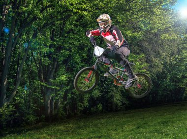 Arka plan ağaç üzerinde genç bmx Bisiklet binici