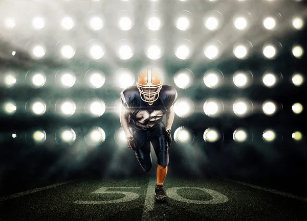 蓝色制服上的聚光灯背景的足球运动员 — 图库照片