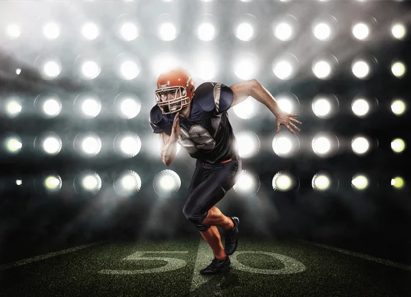 Joueur de football en uniforme bleu sur herbe éclairée par des projecteurs — Photo