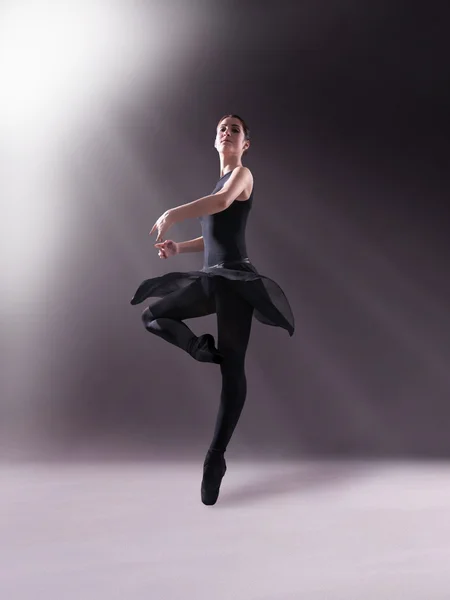 Baletka v černém oblečení pózuje na prsty, studio pozadí — Stock fotografie