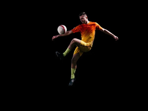 Professionell fotbollspelare i rött sparkar boll i hopp — Stockfoto