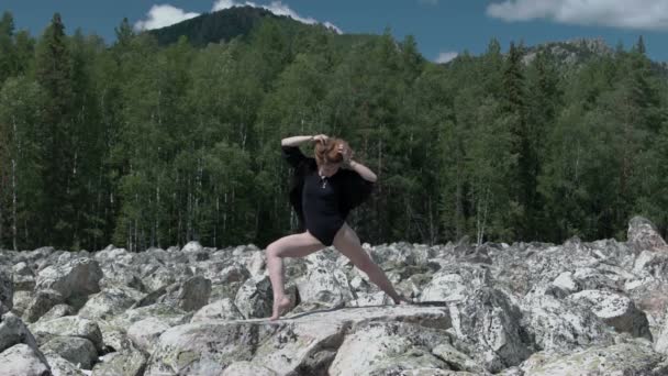 Girl does yoga on the rocks — Stock Video