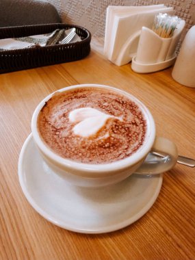 Gün ortasında sıcak bir kafede kremalı ve köpüklü kahve servis edilir.