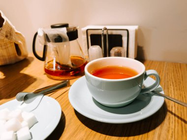 Warm tea served with sugar cubes in a cozy cafe setting during afternoon break