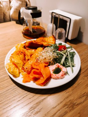 Delicious brunch plate with smoked salmon, salad, and toast served with coffee