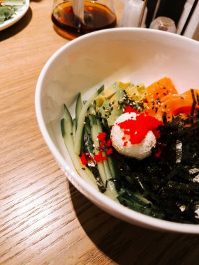 Delicious bowl of fresh sushi ingredients served in a cozy restaurant at dinner time