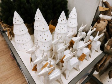 White ceramic holiday decorations displayed for sale in a store during the festive season
