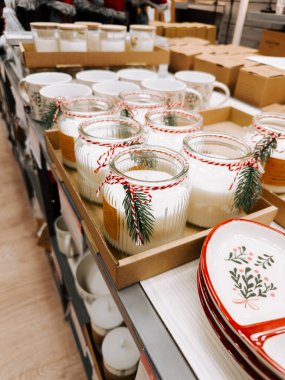 Candles and decorative dishes arranged on a store display for the holiday season