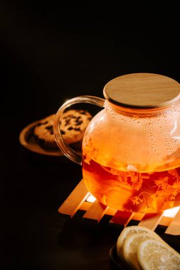 Enjoying black tea with fresh lemon and cookies on a cozy evening