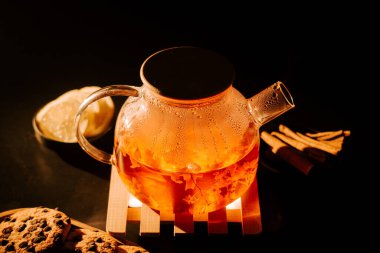 Bright infusion of black tea with spices and cookies in a cozy setting at night
