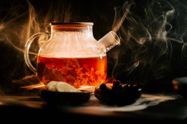 Brewing rich black tea with aromatic steam and lemon slices in a cozy setting