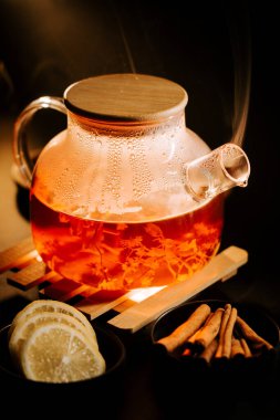 Warm black tea with spices and lemon slices served in a cozy setting