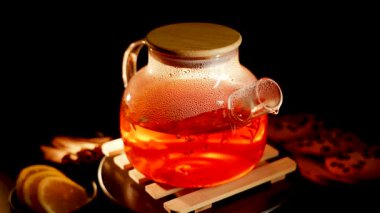 Brewing aromatic black tea with lemon and spices in a cozy setting