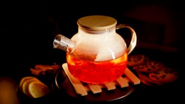 Brewing black tea with lemon and cookies on a cozy evening