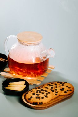 Delightful tea served with cookies and lemon slices on a light background setting