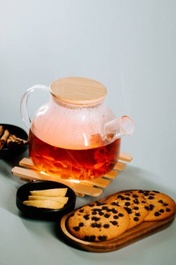 Tea brewed with spices and served with cookies on a wooden tray at a cozy setting
