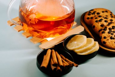 Enjoying warm tea with lemon slices and delicious cookies on a cozy table