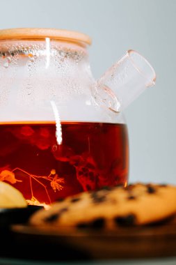 Warm herbal tea brewing beside freshly baked cookies on a wooden surface
