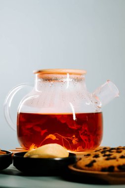 Brewing fresh herbal tea with cookies on a cozy table setting in the afternoon