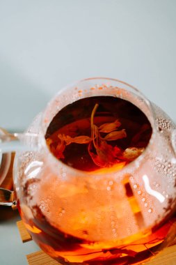 Enjoying a warm cup of herbal tea with delicate petals on a cozy afternoon at home