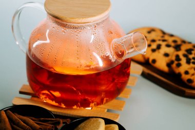 Brewing herbal tea with spices and cookies on a cozy kitchen table