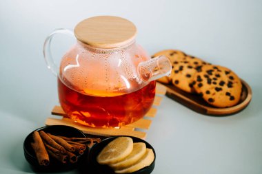 Warm tea served with cookies and spices for a cozy afternoon snack