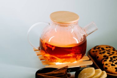 Warm tea brewing with cookies and spices on a cozy evening in a serene setting