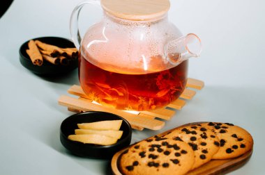 Warm tea with cookies and fruit on a cozy table setting for a relaxing evening