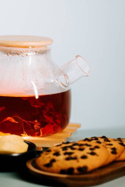 Warm tea brewing with fresh cookies on a wooden tray in a cozy setting