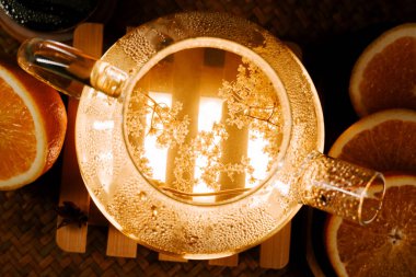 Warm green tea surrounded by fresh oranges creates a peaceful atmosphere in a cozy setting