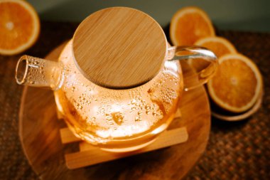 Enjoying freshly brewed green tea in a cozy setting with orange slices nearby