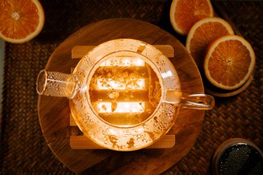 Sipping fragrant green tea with orange slices in a cozy setting at sunset
