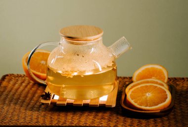 Enjoying a refreshing cup of green tea with citrus slices on a cozy wooden table