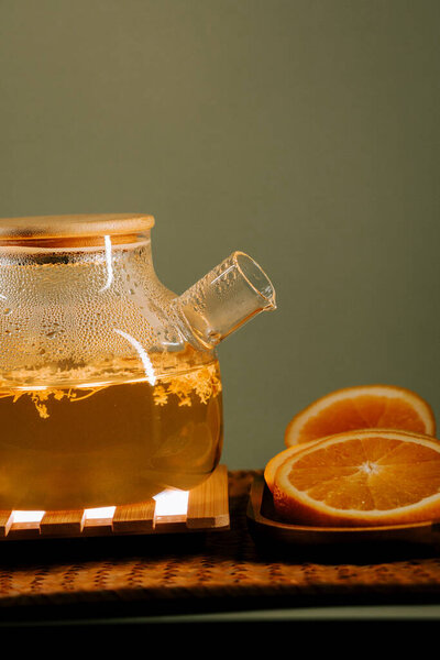 Refreshing green tea with orange slices in a cozy setting