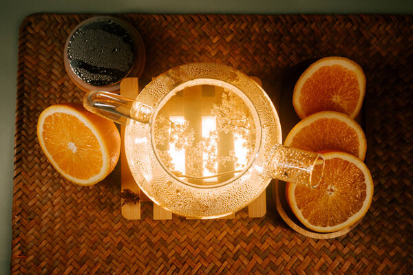 Enjoying a calming moment with green tea and fresh oranges on a warm evening