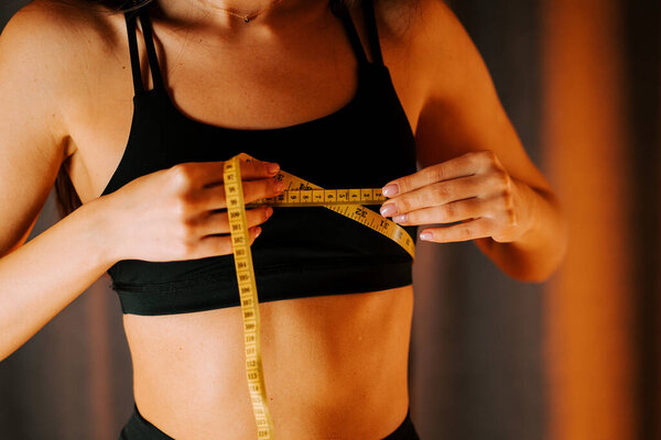 Измерение размера тела во время тренировки дома в теплой обстановке освещения