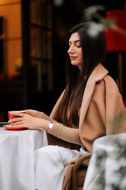 Kadınlar rahat bir sabah atmosferinde büyüleyici İtalyan kafesinde kahveden hoşlanırlar.