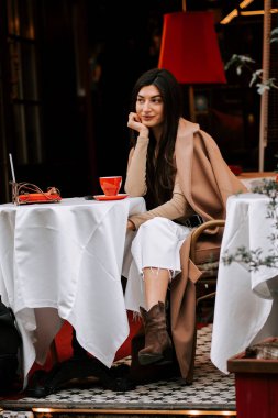 Şehrin göbeğindeki bir İtalyan kahvecisinde kahve içen bir kadın.