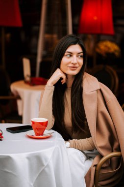 Kadın sakin bir öğleden sonra, atmosferik bir İtalyan kahve dükkanında kahveden hoşlanıyor.