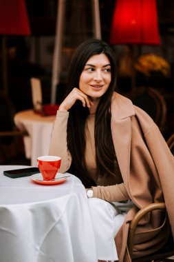 Sıcak bir öğleden sonra, eski bir İtalyan kahve dükkanında kahve içen bir kadın.