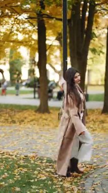 Renkli yapraklarla çevrili bir parkta güneşli bir sonbahar gününün tadını çıkarıyorum.