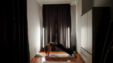 Konforlu bir odada çekirdek kuvvete ve esnekliğe odaklanan ev çalışması oturumu