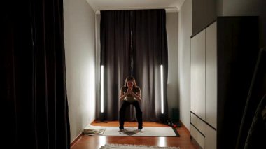 Akşam ışığında çömelme ve çekirdek kuvvete odaklanan ev çalışması rutini