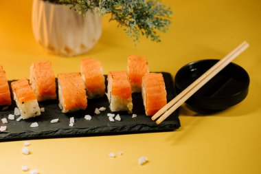 Soya sosu ve yemek çubuklarıyla servis edilmiş taze suşi ruloları.