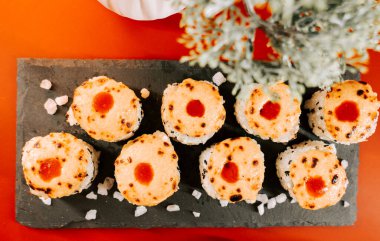 Suşi dürümleri canlı bir yemek ortamında süslü tabakta servis edilir.