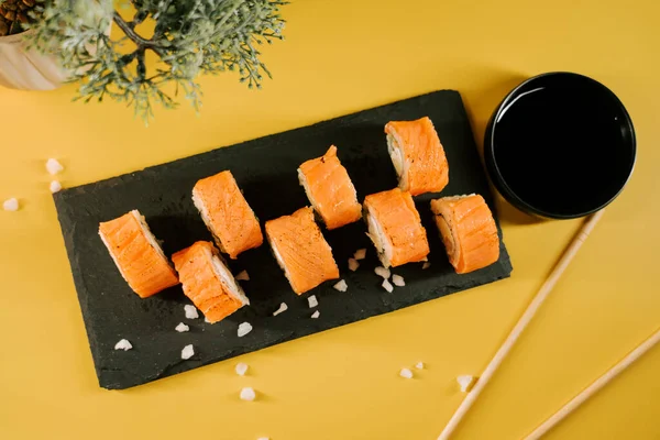 Soya sosu ve yemek çubuklarıyla servis edilen taze suşi ruloları.