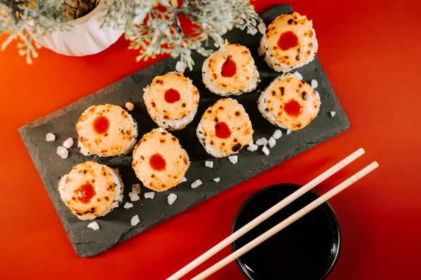 Lezzetli suşi ruloları yemek çubukları ve sos ile servis edilir.