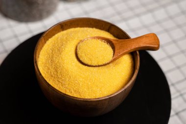 Tahta bir kasede taze öğütülmüş mısır ezmesi ve pişirmeye hazır bir kaşık.